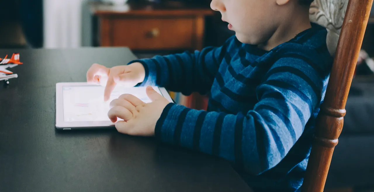 Tablette harf öğrenen bir çocuk
